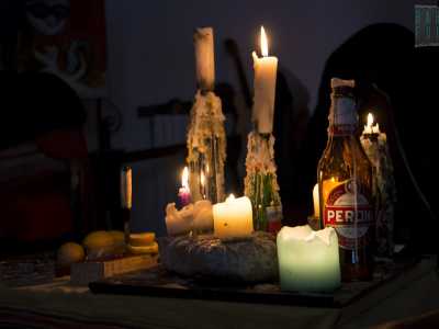 Al centro notiamo un altro tavolino coperto da una tovaglia gialla sbiadita. Su di essa adocchiamo alcune delle candele vitali per combattere l'oscurit� della sera, inserite in bottiglie di Peroni vuote